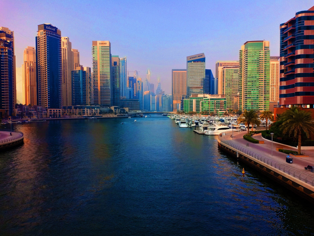 white and black boat on body of water near city buildings during daytime