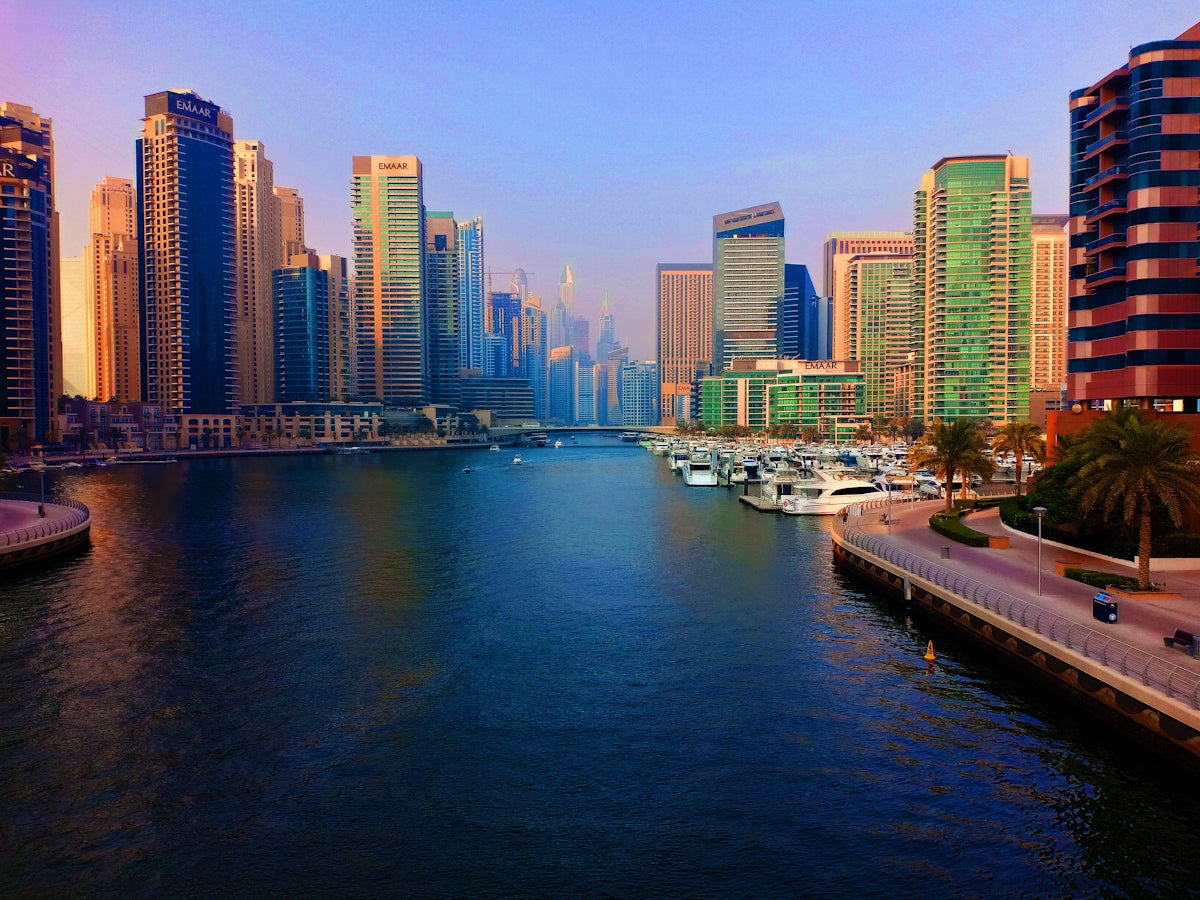 white and black boat on body of water near city buildings during daytime