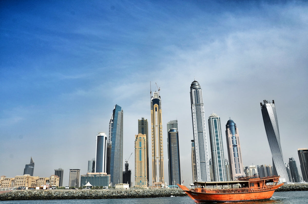 a boat floating on top of a body of water near tall buildings