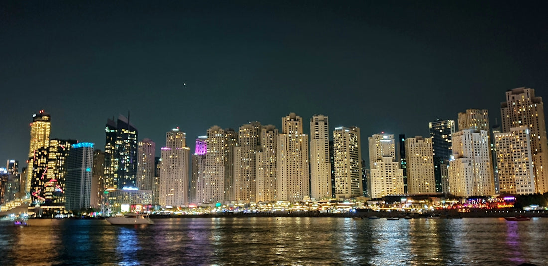 a city skyline at night with lights reflecting off the water