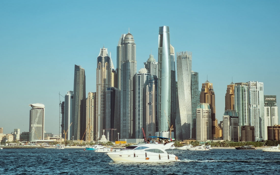 A boat in a body of water with a city in the background