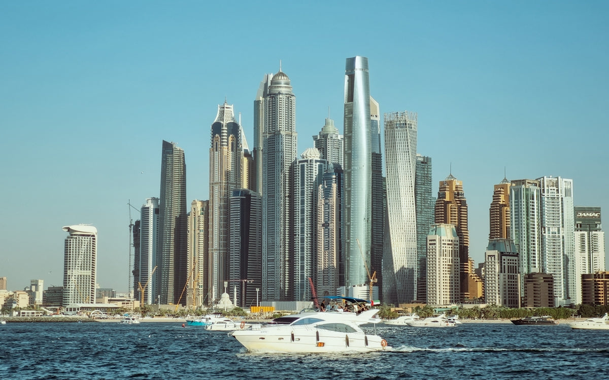 A boat in a body of water with a city in the background