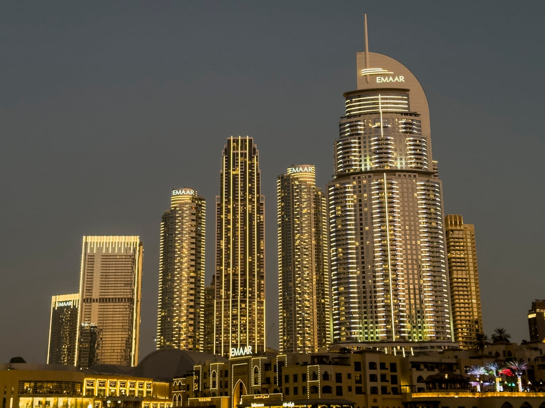 Skyscrapers illuminated against a twilight sky.