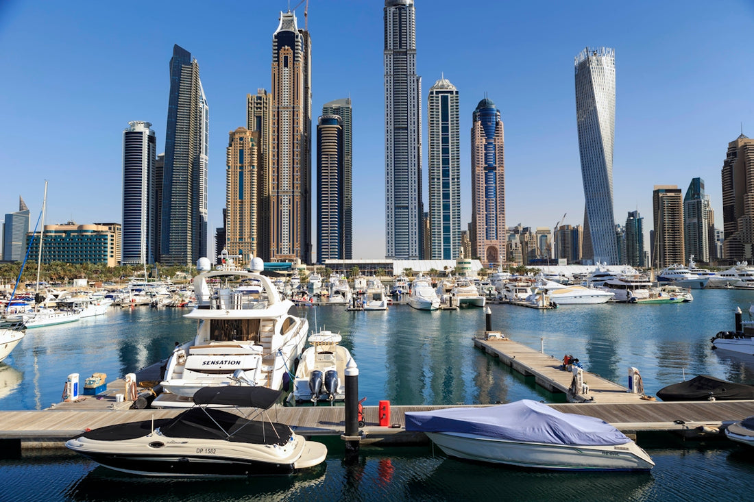 Boats and skyscrapers line a beautiful harbor.