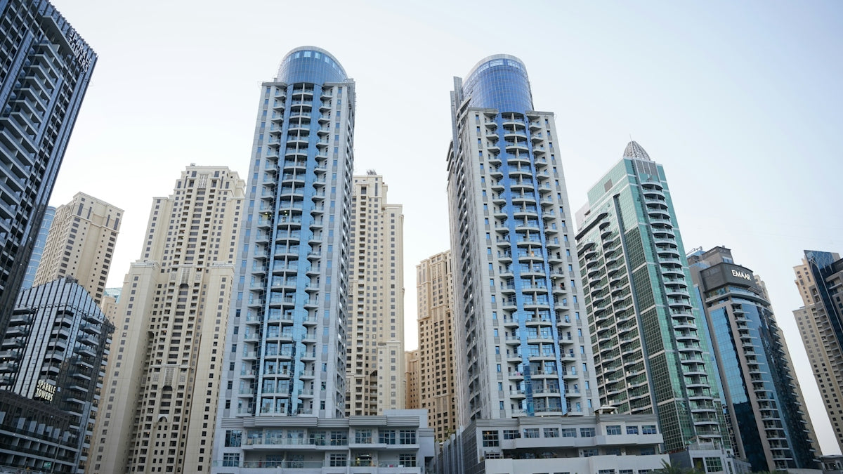 Modern glass skyscrapers in Dubai Marina under a clear sky