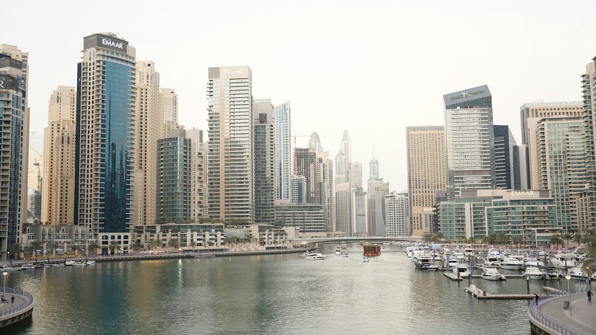 Modern skyscrapers lining the Dubai Marina canal with boats docked at the piers